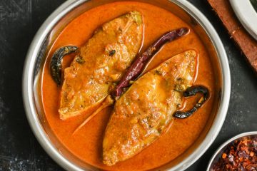 Pomfret Fish Curry in a silver bowl with curry leaves and red chillies.