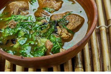 Methi Mutton Curry in a brown earthen bowl