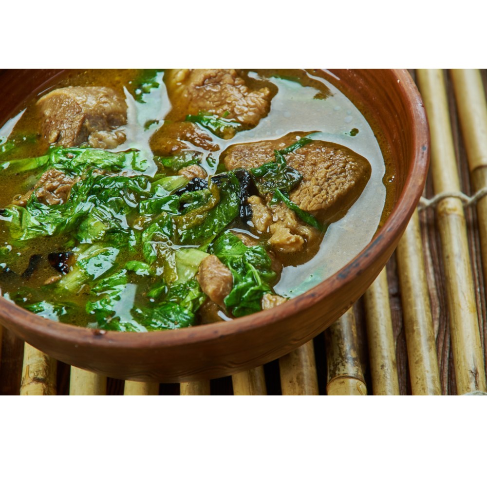 Methi Mutton Curry in a brown earthen bowl