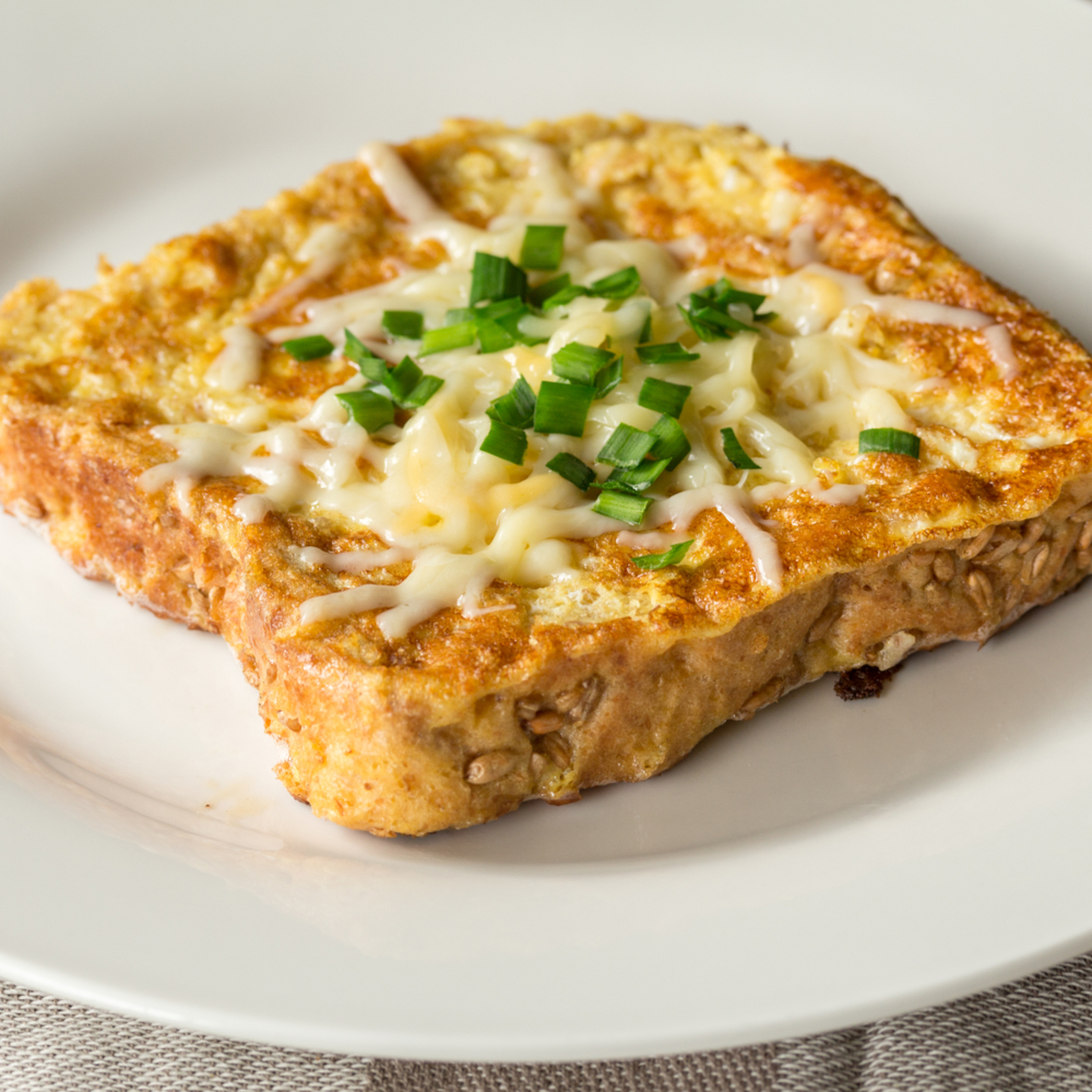 Savoury French Toast on a White Plate with Chives and Cheese on Top