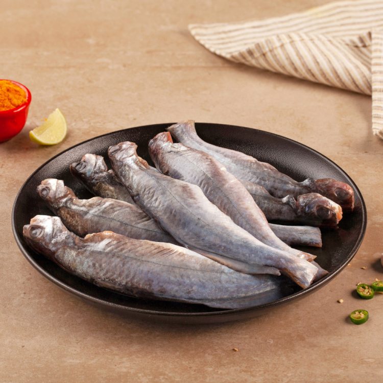Cut & cleaned Tengra fish in a black bowl on a wooden table.
