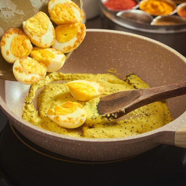 Fried eggs being added to Dim Posto gravy