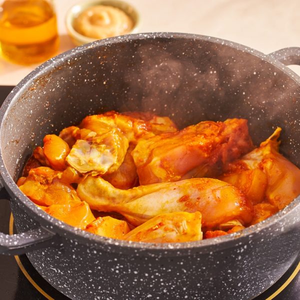 Chicken in pot for Murgir Lal Jhol