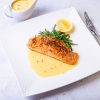 Fish is lemon butter sauce in a white plate