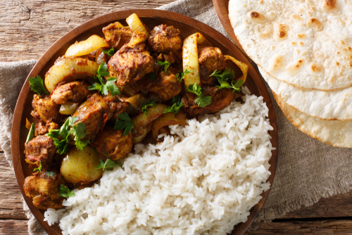 Murgh Do Pyaza on a plate paired with rice and roti.